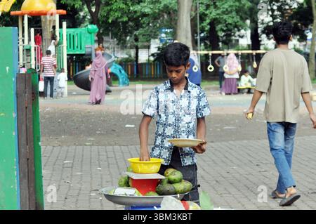 Dhaka, Segunbagicha, Bangladesh. 24 juin 2025. Une 24, 2025 Dhaka Bangladesh :.Kishore Kabir. Il allait à Ramna Park avec sa mère depuis qu'il était enfant. Kabir a dit que depuis son enfance, il vendait des fleurs au parc Ramna. Maintenant, il aide sa mère en coupant et en vendant des mangues et des épices. Kabir voulait lire et écrire. À cause de la pauvreté, il ne pouvait pas. (Crédit image : © Azmal Hoq Helal/ZUMA Press Wire) USAGE ÉDITORIAL SEULEMENT ! Non destiné à UN USAGE commercial ! Banque D'Images
