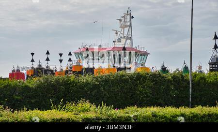 28 mai 2025 - Vlissingen-pays-Bas : navire des garde-côtes néerlandais amarré à un dépôt de bouées dans le port de Vlissingen avec des bouées de navigation colorées entreposées Banque D'Images