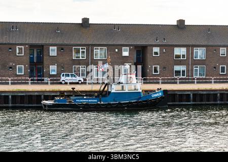 28 mai 2025 - Vlissingen-pays-Bas : petit remorqueur Charlie de Polderman Berging amarré sur un quai à Vlissingen, en face de logements sociaux avec uppe Banque D'Images