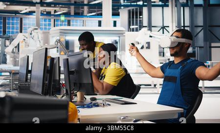 Technicien afro-américain dans l'usine de panneaux solaires utilisant des lunettes VR, optimisant les mises en page à l'aide d'un logiciel de CAO. Ouvrier d'usine photovoltaïque utilisant la technologie de réalité virtuelle pour faire des arrangements. Caméra B. Banque D'Images