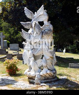 Scène de cimetière paisible avec des statues d'ange et de colombe baignées de soleil au cimetière d'Oakwood à Raleigh, Caroline du Nord. Banque D'Images