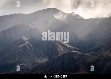 Rayons de soleil dans les montagnes, près de Arrowtown, Central Otago, Île du Sud, Nouvelle-Zélande Banque D'Images