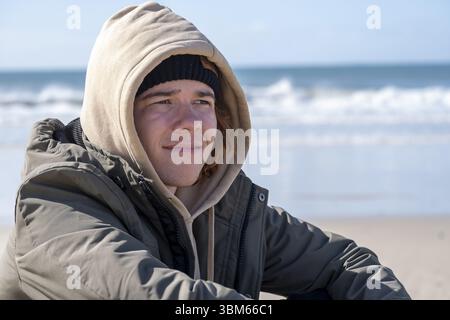 Jeune homme aux cheveux roux, assis sur la plage, Jeffreys Bay près de Port Elizabeth, Garden route, Eastern Cape, Afrique du Sud, Afrique Banque D'Images