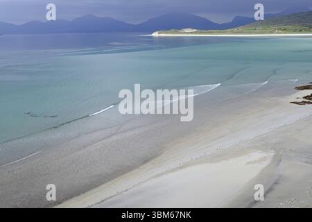 Les vagues douces sillonnent la large plage vide sur fond de montagnes et d'une mer calme, Seilebost Beach, île de Harris, Hébrides, Écosse, United Kin Banque D'Images