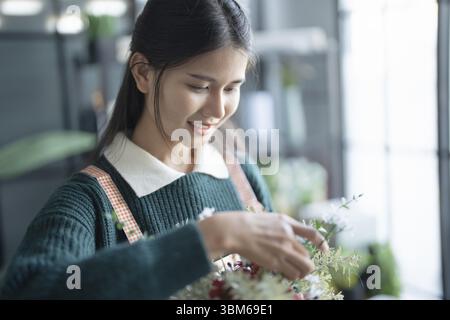 Heureuse femme asiatique fleuriste Startup petite entreprise PME réussie dans le magasin de fleurs Banque D'Images