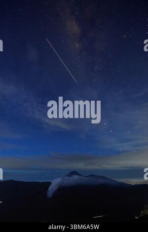 Étoiles et fumage Mt bromo (Gunung bromo) et Mt Semeru au loin, Java oriental, Indonésie Banque D'Images