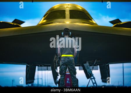 Un aviateur de l'United States Air Force se prépare à marécher un bombardier furtif B-2 Spirit pour décoller en soutien au déploiement d'un Bomber Task Force de Whiteman Air Force base dans le Missouri le 15 août 2024. (ÉTATS-UNIS) Banque D'Images