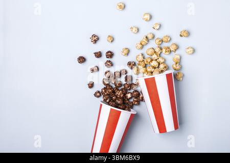 Pop-corn au chocolat caramel doux dans une tasse rouge blanche rayée de papier Banque D'Images