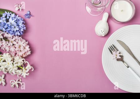 Table de fête le printemps avec des fleurs de jacinthes sur fond rose Banque D'Images