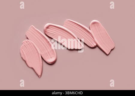 Échantillons d'ombres à paupières roses sur fond beige. Des échantillons de coups de maquillage crème Banque D'Images