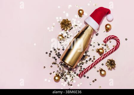 Composition de Noël faite de champagne doré dans le chapeau de Santa, canne à sucre et étincelles, espace de copie Banque D'Images