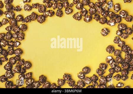Cadre de pop-corn au chocolat sur fond jaune Banque D'Images
