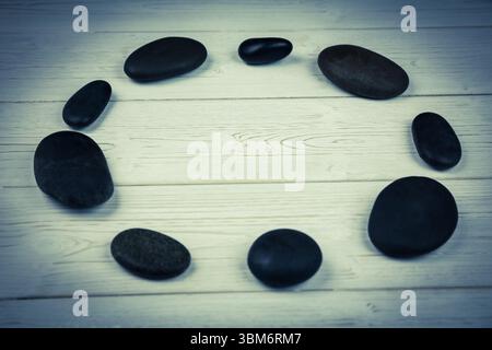 Galets noirs sur plancher de bois franc Banque D'Images