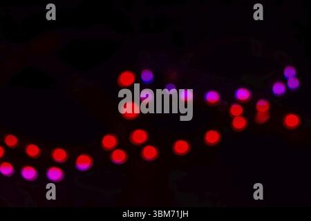 Lumières bokeh rouges et violettes bichromes au néon sur noir. Concept festif Banque D'Images