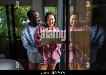 Un couple heureux et multinational qui sont des nomades numériques et travaillent dans un pays différent chaque mois Banque D'Images