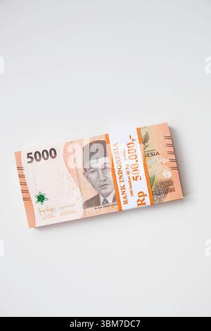 Pekanbaru, Indonésie - 21 mars 2025 : une pile de billets de banque rupiah indonésiens RP 5,000 isolés sur fond blanc pour THR sur Eid al-Fitr ou Lebaran Banque D'Images