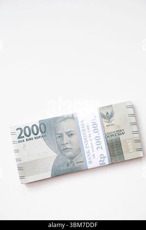 Pekanbaru, Indonésie - 21 mars 2025 : une pile de billets de banque rupiah indonésiens RP 2,000 isolés sur fond blanc pour THR sur Eid al-Fitr ou Lebaran Banque D'Images