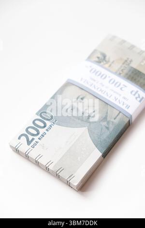 Pekanbaru, Indonésie - 21 mars 2025 : une pile de billets de banque rupiah indonésiens RP 2,000 isolés sur fond blanc pour THR sur Eid al-Fitr ou Lebaran Banque D'Images