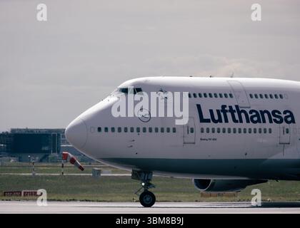Lufthansa Boeing 747-400 jumbo jet roulant sur piste à l'aéroport international, vue du nez avec cockpit et logo Banque D'Images