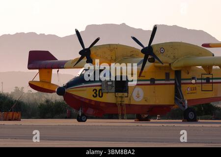 Bombardier CL-415 avion de lutte contre les incendies de l'Italien Vigili del Fuoco sur la base aérienne au lever du soleil, cloué au sol avec la montagne en toile de fond Banque D'Images