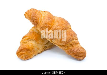 Deux gros croissants fraîchement cuits sur une surface blanche avec l'un couché sur l'autre. Bonne image des confiseurs. Banque D'Images