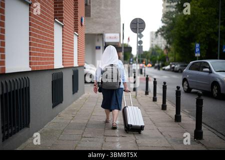Varsovie, Pologne. 24 juin 2025. Une religieuse marche avec un chariot à bagages à Varsovie, en Pologne, le 24 juin 2025. (Photo de Jaap Arriens/Sipa USA) crédit : Sipa USA/Alamy Live News Banque D'Images