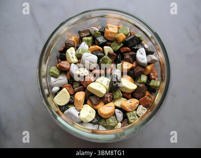 Un pot en verre plein de chocolats enrobés de bonbons. Banque D'Images