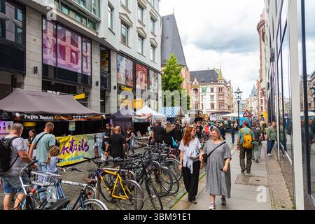 Leipzig, Allemagne – 7 juin 2025 : scène de rue lors d'un festival public à Leipzig avec des gens marchant devant des stands de nourriture et de boissons, des vélos garés en t Banque D'Images