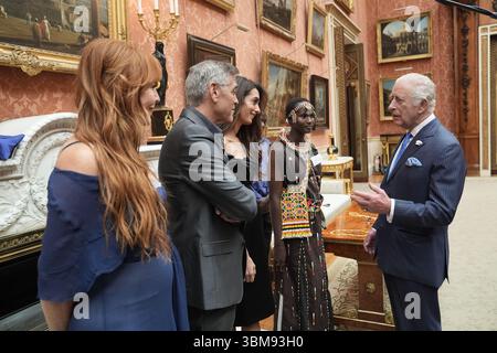 Le roi Charles III s'entretient (de gauche à droite) avec Charlotte Tilbury, George et Amal Clooney lors d'une réception pour les lauréats des King's Trust Awards 2025 au Palais de Buckingham, à Londres. Date de la photo : mercredi 25 juin 2025. Banque D'Images