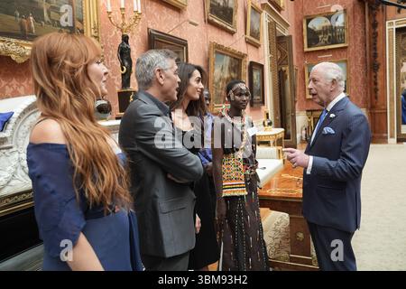 Le roi Charles III s'entretient (de gauche à droite) avec Charlotte Tilbury, George et Amal Clooney lors d'une réception pour les lauréats des King's Trust Awards 2025 au Palais de Buckingham, à Londres. Date de la photo : mercredi 25 juin 2025. Banque D'Images