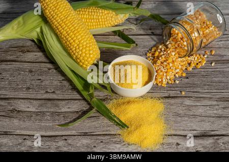 Épis de maïs, grains et farine reposant sur une table en bois rustique Banque D'Images