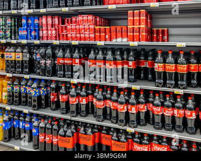 Italie - 25 juin 2025 : Coke et Pepsi Cola dans des bouteilles en plastique et en canettes exposées sur l'étagère pour la vente dans un supermarché italien Banque D'Images