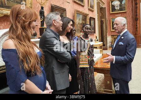 RETRANSMIS ENLEVANT LE NOM DE FAMILLE D'ALICE COMME DEMANDÉ PAR LE KING'S TRUST INTERNATIONAL DANS LE CADRE DE LEUR PROTOCOLE DE SAUVEGARDE le roi Charles III parle avec (de gauche à droite) Charlotte Tilbury, George et Amal Clooney et Alice, lors d'une réception pour les gagnants des King's Trust Awards 2025 au Palais de Buckingham, à Londres. Date de la photo : mercredi 25 juin 2025. Banque D'Images