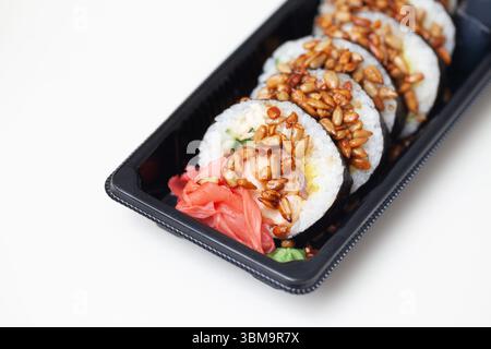 Plateau à sushis à emporter avec gingembre et sauce. Petits pains japonais frais dans un récipient noir. Nourriture savoureuse à emporter. Déjeuner ou dîner asiatique sain. Banque D'Images