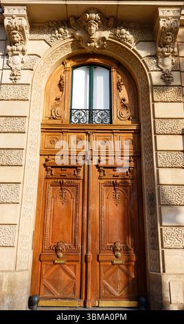 Ancienne porte ornée à Paris, France - ancien immeuble typique. Banque D'Images