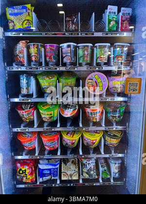 Kiev, Ukraine - 24 juin 2025 : machine affichant une variété de tasses de nouilles instantanées asiatiques et de produits de collation à vendre Banque D'Images