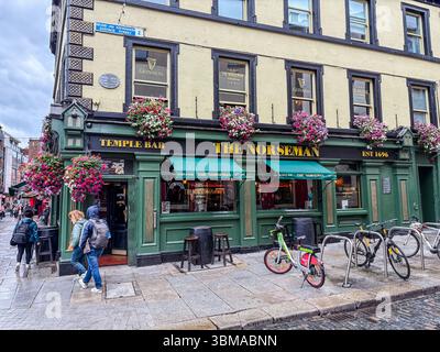 Le Norseman pub, un pub irlandais traditionnel situé dans le quartier de Temple Bar à Dublin, en Irlande, présente des fleurs et une rue pavée. Banque D'Images