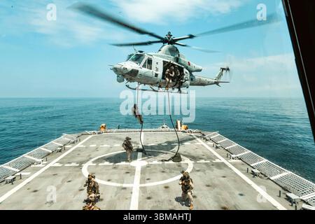 Les membres de la 22e Marine Expeditionary Unit et de l’équipe d’intervention de sécurité maritime de la Garde côtière est mènent une formation d’insertion d’hélicoptères à bord des États-Unis Banque D'Images