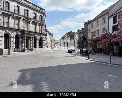 Scène de rue à Kilkenny, en Irlande, avec une architecture historique, des boutiques et des piétons par une journée ensoleillée. Banque D'Images