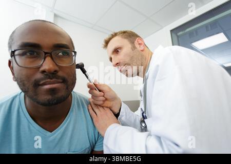 médecin vérifiant l'oreille du patient pendant l'examen médical Banque D'Images