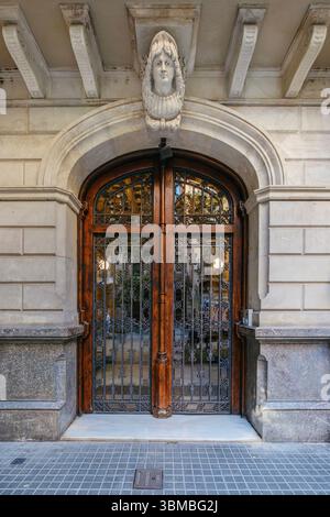 Porte d'entrée en bois ornée d'Un bâtiment classique de Barcelone, avec des détails architecturaux. Design espagnol historique, façade urbaine, Elemen décoratif Banque D'Images