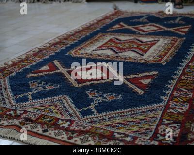 Maroc, Merzouga, 04 juillet 2025. Intérieur d'un atelier de tapis berbère traditionnel dans la région du Sahara, décoré de tapis colorés faits à la main et de weav Banque D'Images