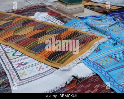Maroc, Merzouga, 04 juillet 2025. Intérieur d'un atelier de tapis berbère traditionnel dans la région du Sahara, décoré de tapis colorés faits à la main et de weav Banque D'Images