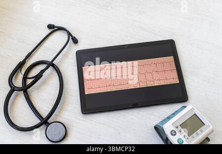Tableau avec phonendoscope, sphygmomanomètre et cardiogramme d'infarctus du myocarde sur la tablette Banque D'Images
