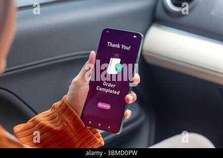 Femme tenant le smartphone affichant la notification de commande terminée. Concept d'achat en ligne. Banque D'Images