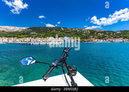 Balade à vélo sur l'île de Baska, vélo électrique garé sur une plate-forme en béton près de la plage de Baska, vue sur le panorama de la ville Banque D'Images