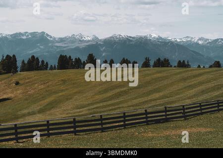 Champ alpin pittoresque avec clôture en bois et vue sur les montagnes enneigées dans les Dolomites, Italie. Photo de haute qualité Banque D'Images