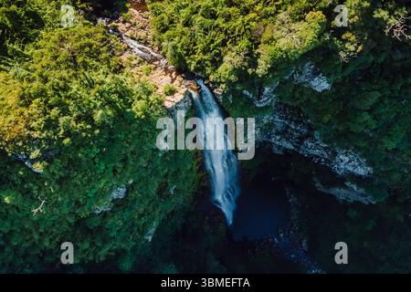 Vue aérienne d'une superbe cascade plongeant dans un canyon de la jungle entouré d'une forêt verdoyante. Banque D'Images