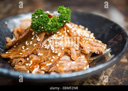 Jarret de bœuf aux cinq épices, élégamment plaqué, présentant de tendres tranches infusées d'épices aromatiques, une représentation classique de la cuisine chinoise. Banque D'Images