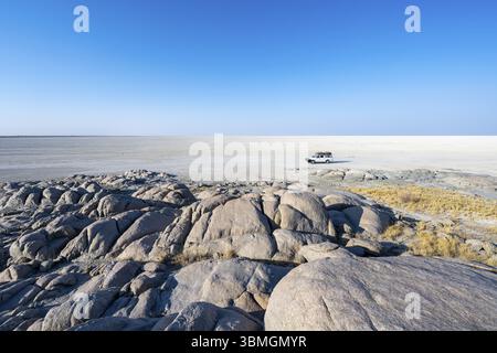 Rochers ronds de l'île de Kubu avec vue sur la salière, véhicule hors route sur la salière, île de Kubu (Lekubu), Sowa Pan, Makgadikgadi Salt Pans, Bots Banque D'Images